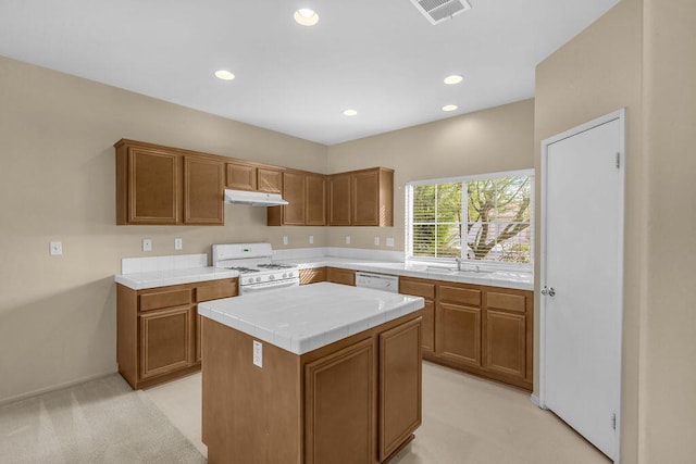 kitchen featuring sink, a kitchen island, light carpet, and white appliances