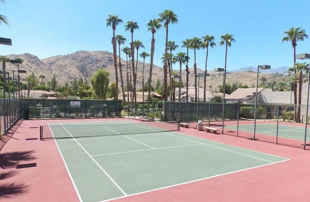 view of tennis court featuring a mountain view and basketball hoop