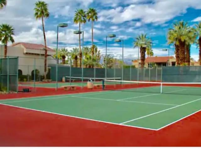 view of tennis court featuring basketball hoop