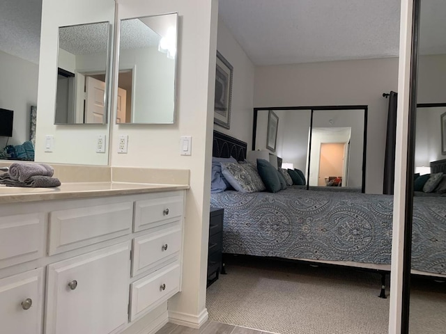 bedroom with a textured ceiling and light carpet