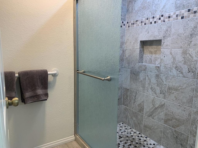 bathroom with an enclosed shower and hardwood / wood-style flooring