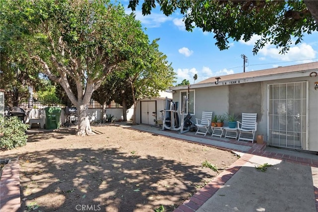 view of yard with a storage shed and a patio