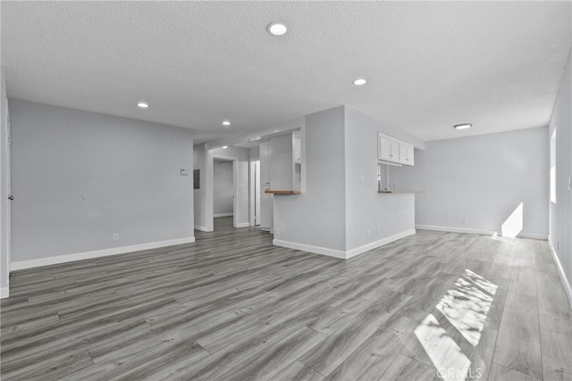 unfurnished living room featuring light hardwood / wood-style floors and a textured ceiling