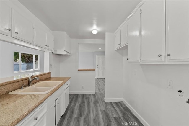 kitchen featuring hardwood / wood-style flooring, white cabinetry, and sink