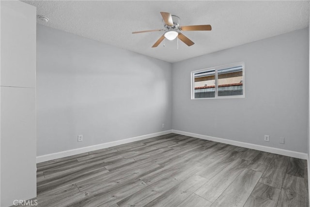 unfurnished room featuring a textured ceiling, hardwood / wood-style flooring, and ceiling fan