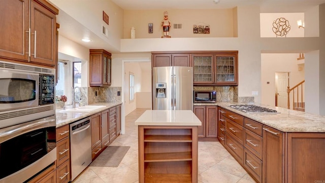 kitchen with sink, backsplash, kitchen peninsula, stainless steel appliances, and a high ceiling