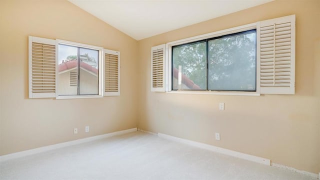 carpeted empty room featuring lofted ceiling and a wealth of natural light