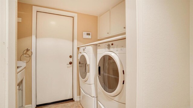 washroom featuring washing machine and dryer and light tile patterned floors