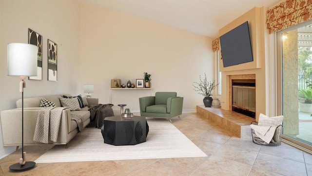 living room with a tiled fireplace, tile patterned flooring, and vaulted ceiling