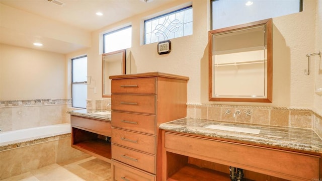 bathroom featuring vanity and a relaxing tiled tub