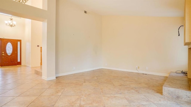 tiled entryway featuring an inviting chandelier and a towering ceiling