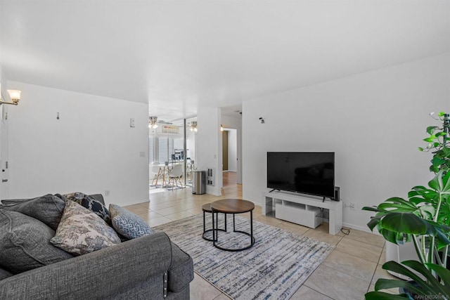 tiled living room featuring ceiling fan with notable chandelier