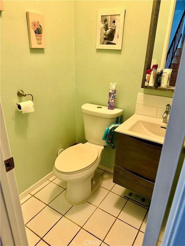 bathroom with tile patterned flooring, vanity, and toilet