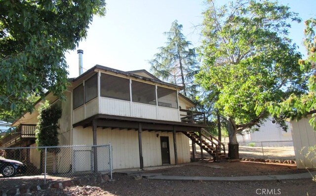 rear view of house featuring a wooden deck and a sunroom