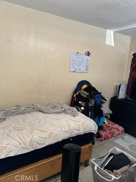 bedroom featuring a textured ceiling and light tile patterned flooring