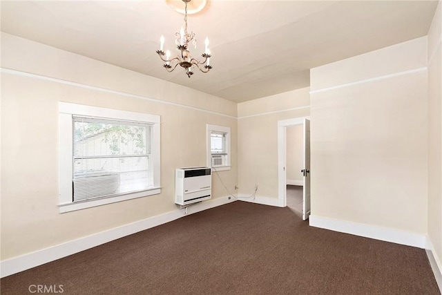 carpeted empty room with heating unit and a notable chandelier