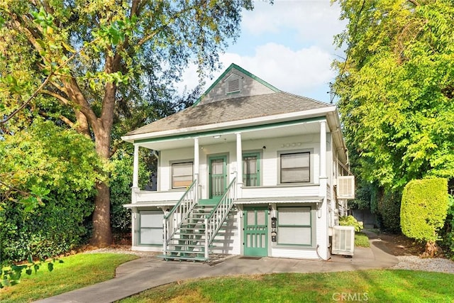 view of front of property with cooling unit, a porch, and a garage