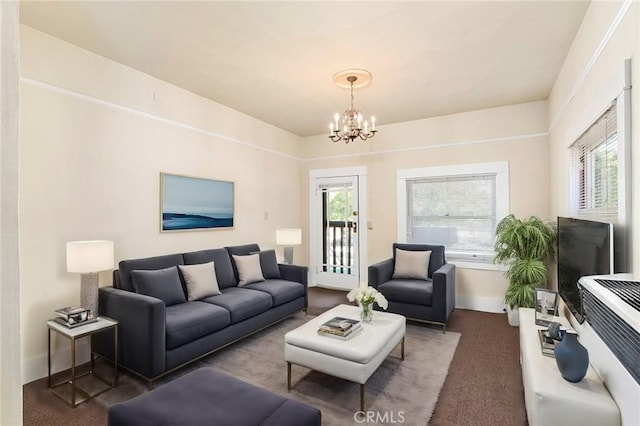 living room with dark carpet and an inviting chandelier