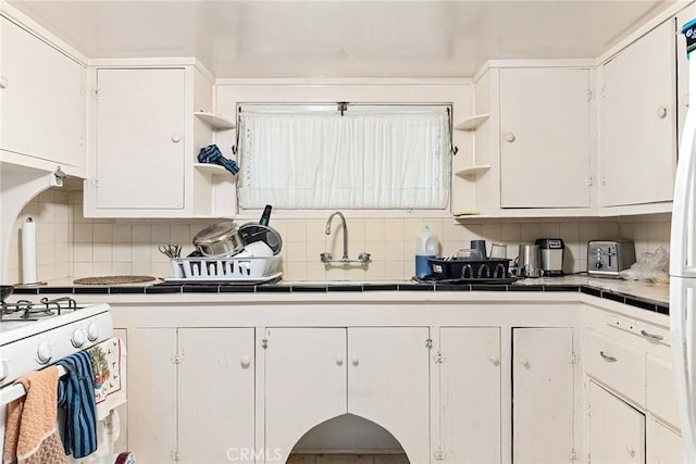 kitchen featuring backsplash, white cabinetry, and tile counters