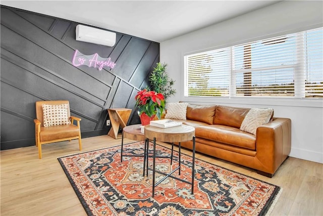 living room featuring light hardwood / wood-style floors and a wall unit AC