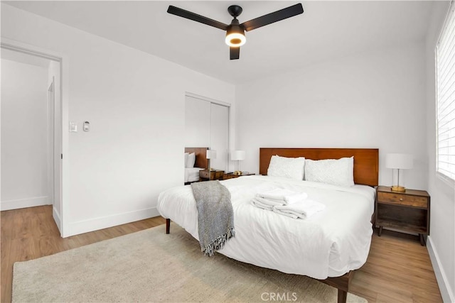 bedroom featuring ceiling fan, light hardwood / wood-style floors, and a closet