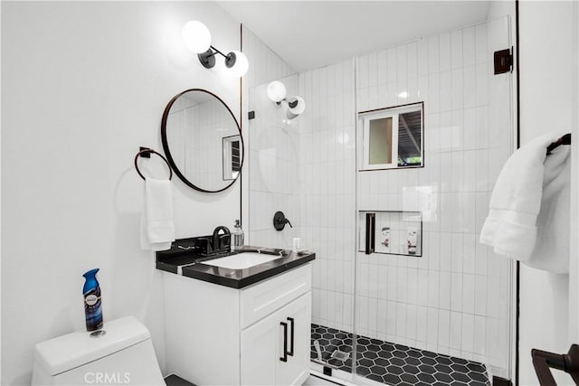 bathroom featuring toilet, an enclosed shower, and vanity