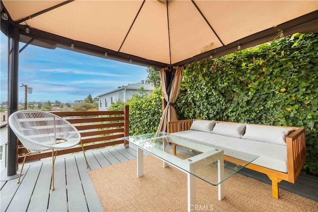 wooden terrace featuring a gazebo and outdoor lounge area