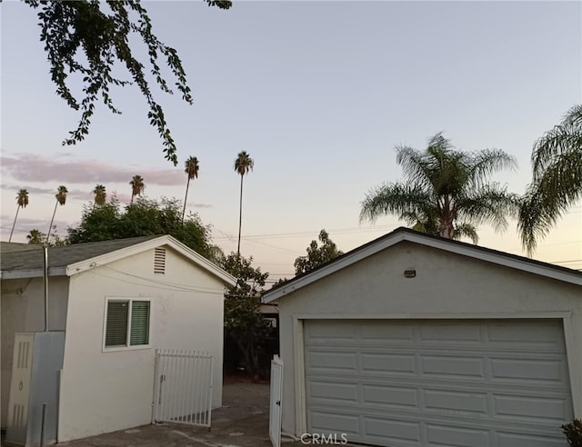 view of garage at dusk