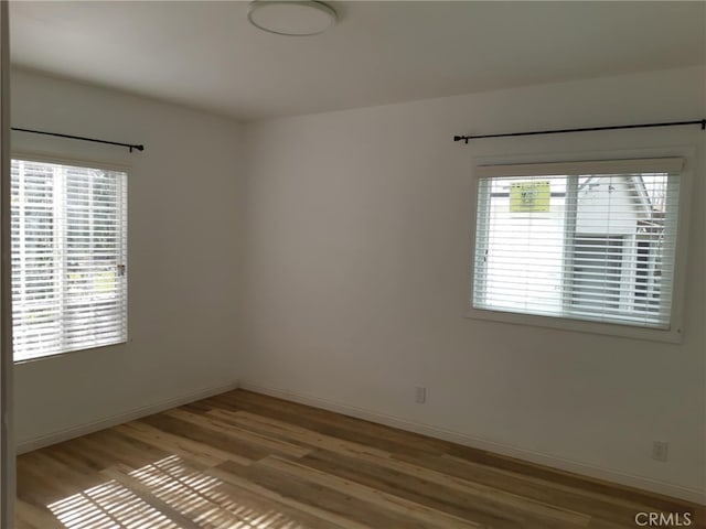 unfurnished room featuring hardwood / wood-style flooring and plenty of natural light