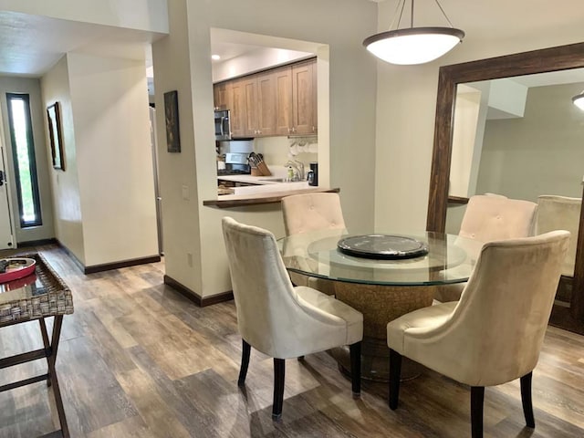 dining space with dark hardwood / wood-style flooring and sink