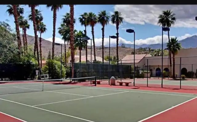 view of sport court with basketball hoop and a mountain view