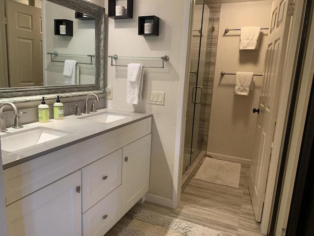 bathroom with vanity, wood-type flooring, and walk in shower