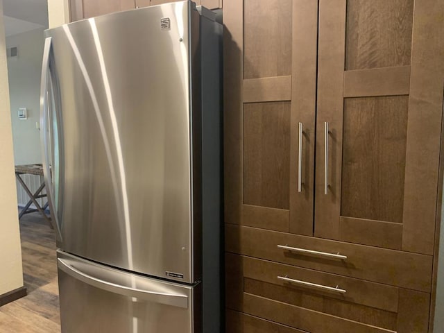 interior details with stainless steel fridge and hardwood / wood-style floors