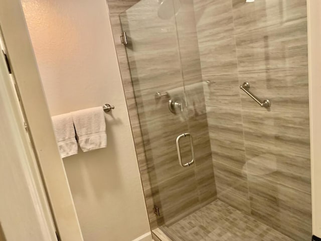 bathroom with a shower with door