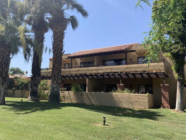 exterior space with a balcony and a lawn