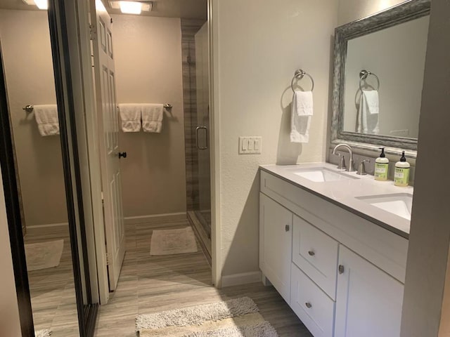 bathroom with hardwood / wood-style floors, vanity, and an enclosed shower