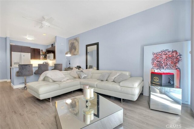 living room featuring light hardwood / wood-style floors and ceiling fan