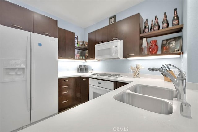 kitchen featuring open shelves, white appliances, a sink, and dark brown cabinets