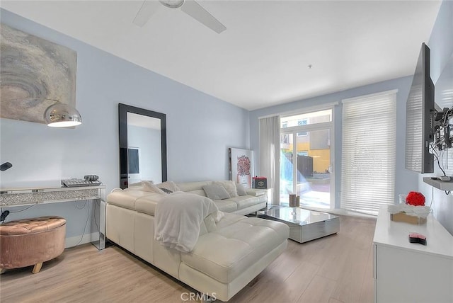 living area featuring light wood-style flooring and a ceiling fan