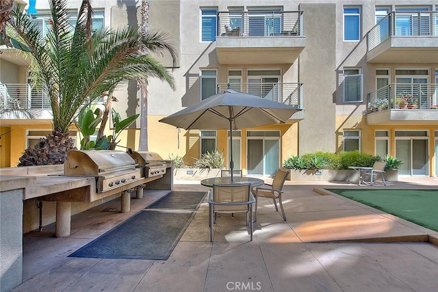 back of property featuring a patio, an outdoor kitchen, and stucco siding