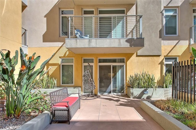 back of house with a patio area, fence, and stucco siding