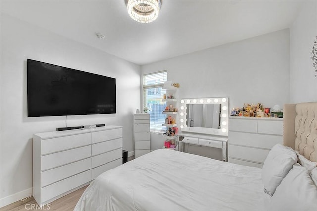 bedroom with light wood-type flooring and baseboards