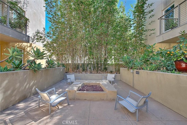 view of patio featuring an outdoor fire pit and fence