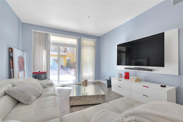 living room featuring baseboards, visible vents, and light wood-style floors