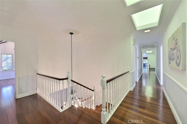 hall with dark hardwood / wood-style floors and a skylight