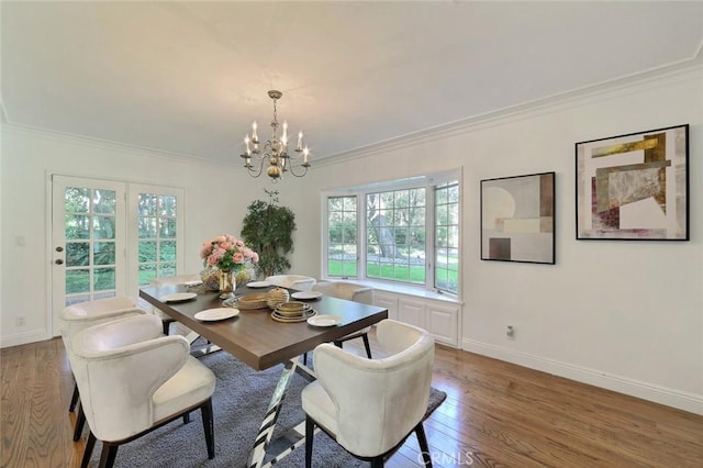 dining space with light wood-type flooring, an inviting chandelier, and ornamental molding