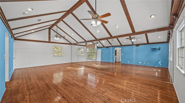 unfurnished living room featuring basketball hoop, beamed ceiling, wood-type flooring, and ceiling fan