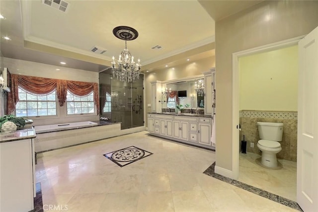 full bathroom featuring vanity, an inviting chandelier, tile walls, shower with separate bathtub, and toilet