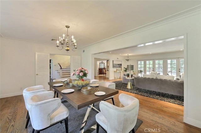 dining area featuring crown molding, light hardwood / wood-style floors, and a notable chandelier