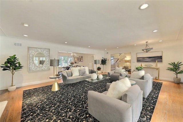 living room featuring light wood-type flooring and crown molding